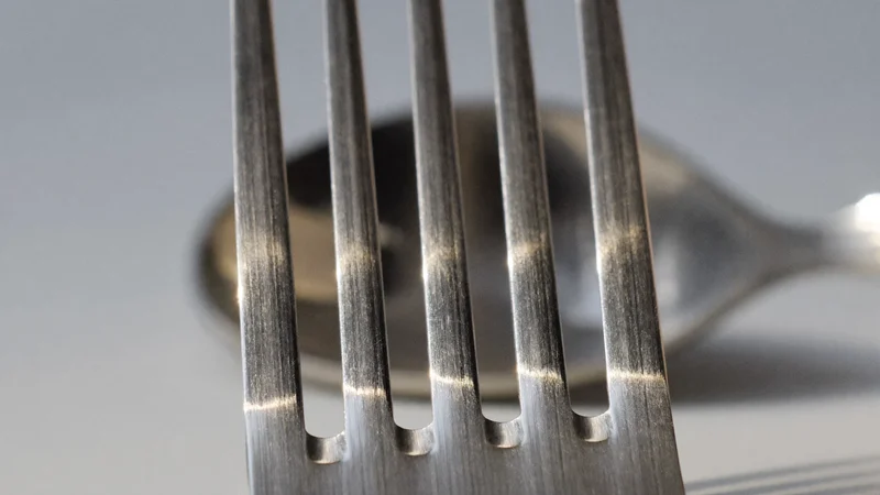 Dettaglio macro delle punte di una forchetta in acciaio spazzolato
